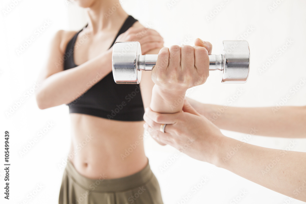 Women are trained to arms in the dumbbell with trainer