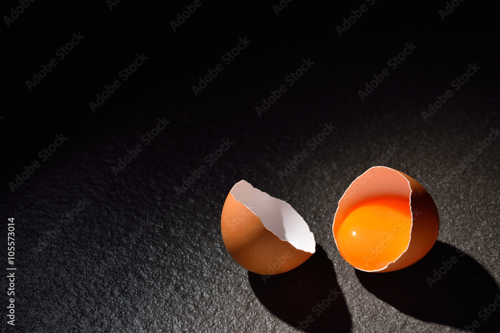 Close up of cracked egg on black table background