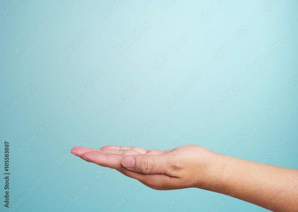 Close-up of  hand isolated on blue background. Palm up