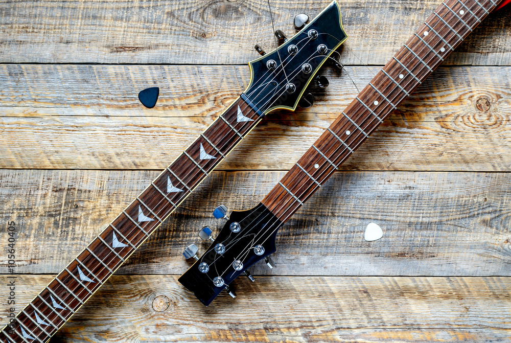 Two electric guitar bodies on wooden board background.