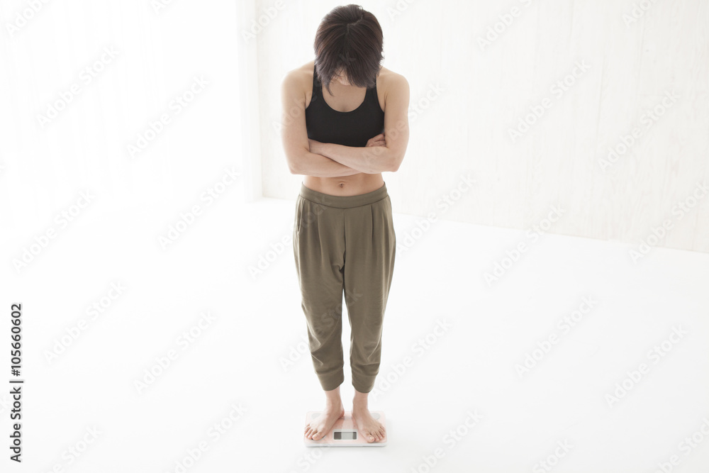 Woman suffering riding a weight scale