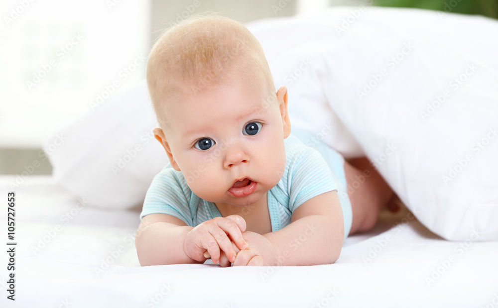 happy newborn baby on bed