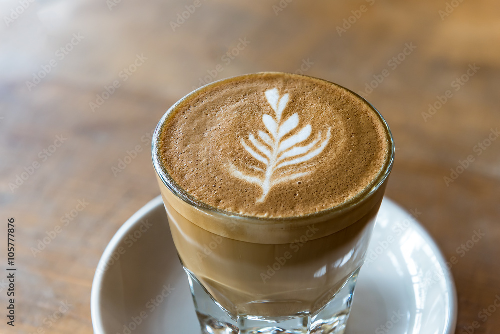 glass of latte coffee on wooden table