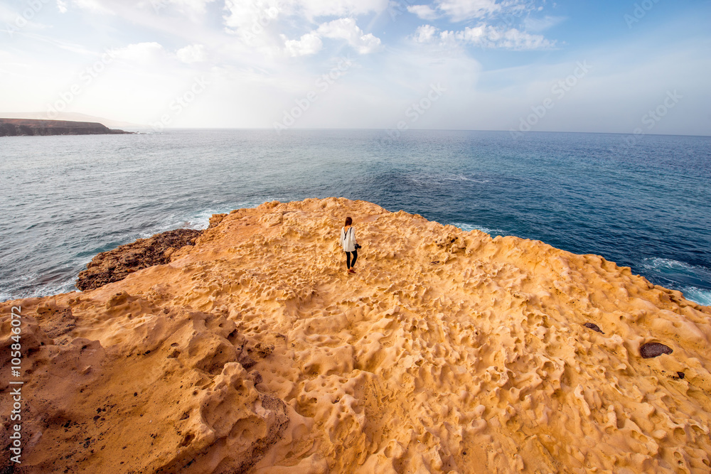 白色石头海岸，一名妇女在Fuerteventura islan的Payara munipalicity的Ajuy村附近行走