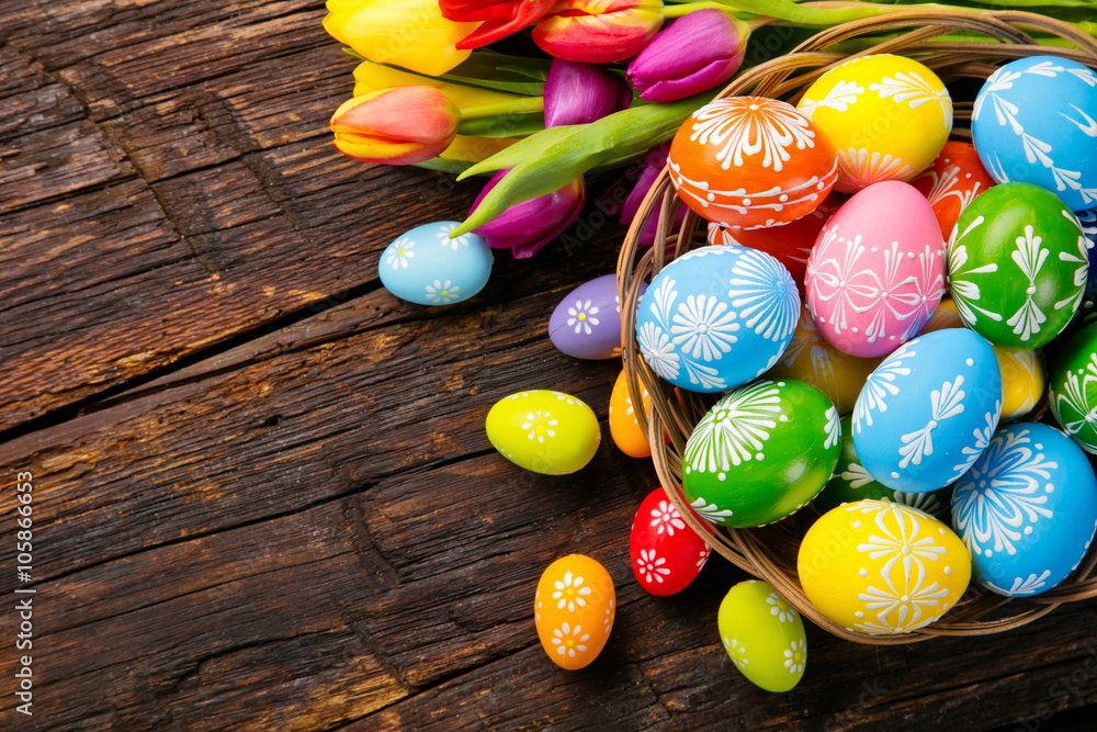 Easter eggs and tulips on wooden planks