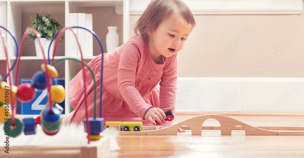 快乐的蹒跚学步的女孩玩玩具