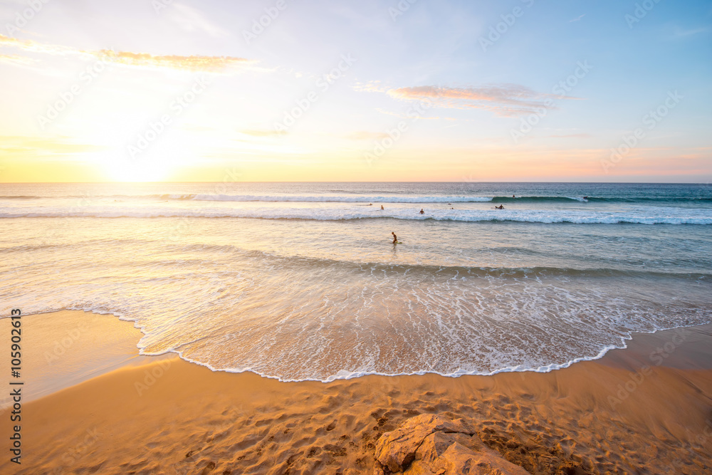 Beautiful beach with surfers swimming near El Cotillo village on Fuerteventura island in Spain