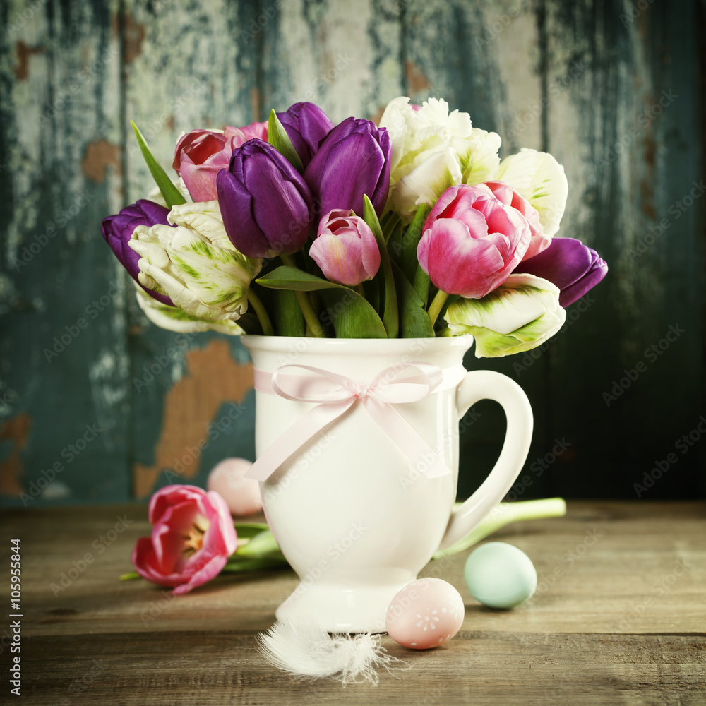 Beautiful tulips bouquet and easter eggs  on wooden table