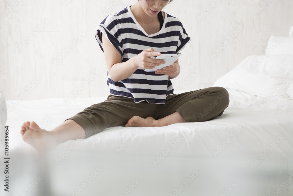 Women are looking at the tablet on the bed