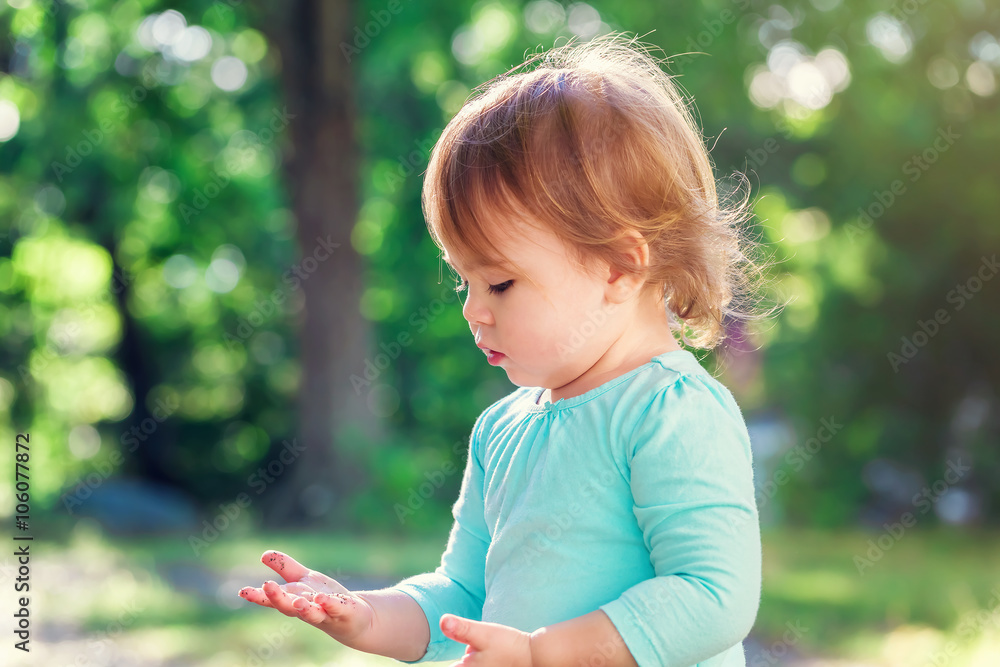 Happy toddler girl playing outside