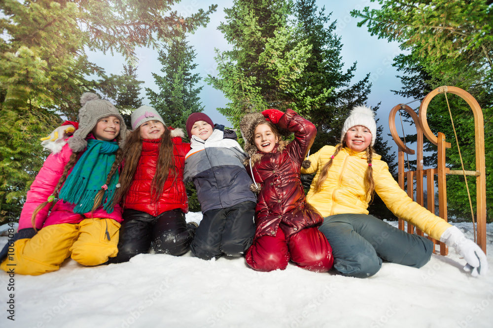 Five kids playing in the snow at wintertime