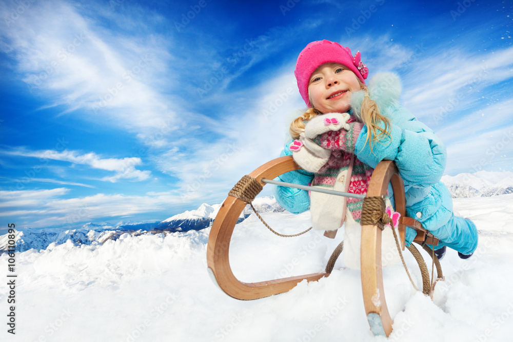 Winter fun in snow mountains girl on sledge