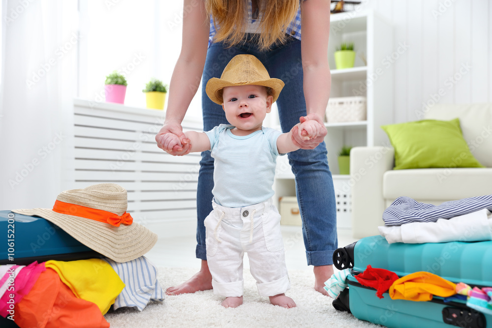 happy baby taddler makes the first step with mother and bags to