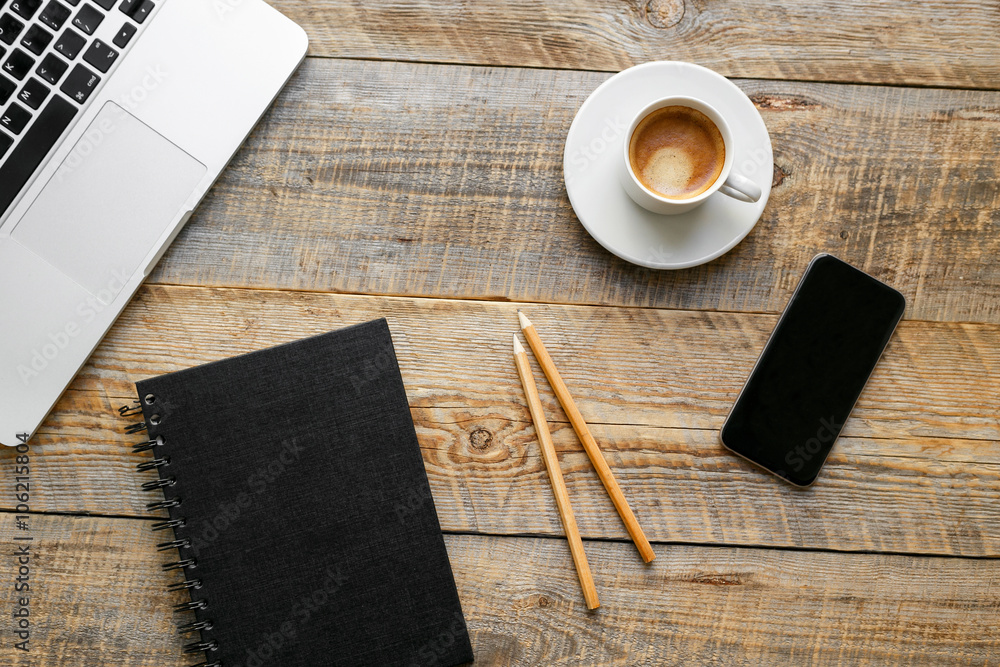 Comfortable working place at wooden table with laptop and coffee