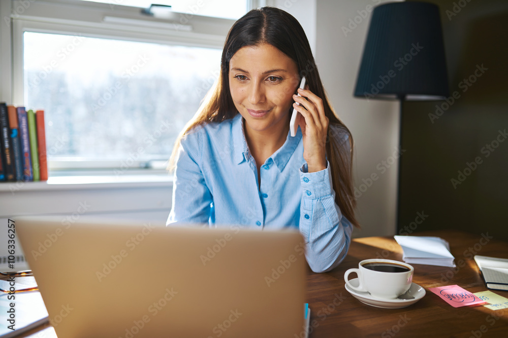 Cheerful young adult business owner on phone