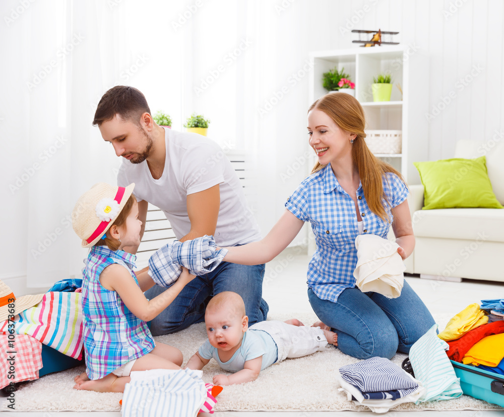 happy family mother, father and two children packed suitcases fo