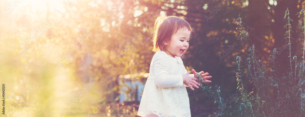 Happy toddler girl playing outside