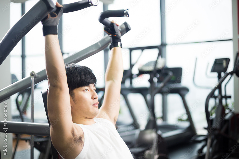 young handsome asian man works out in modern gym