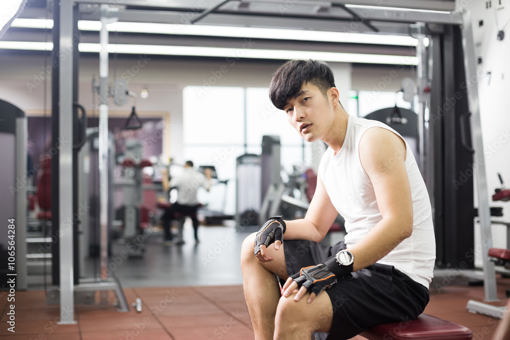 young handsome asian man works out in modern gym