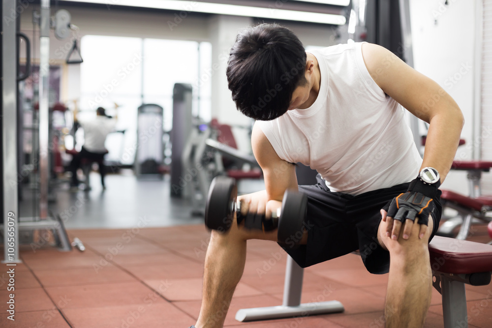 young handsome asian man works out in modern gym