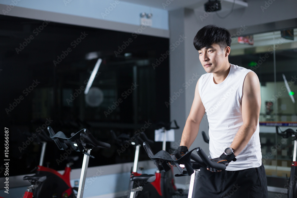 young handsome asian man works out in modern gym