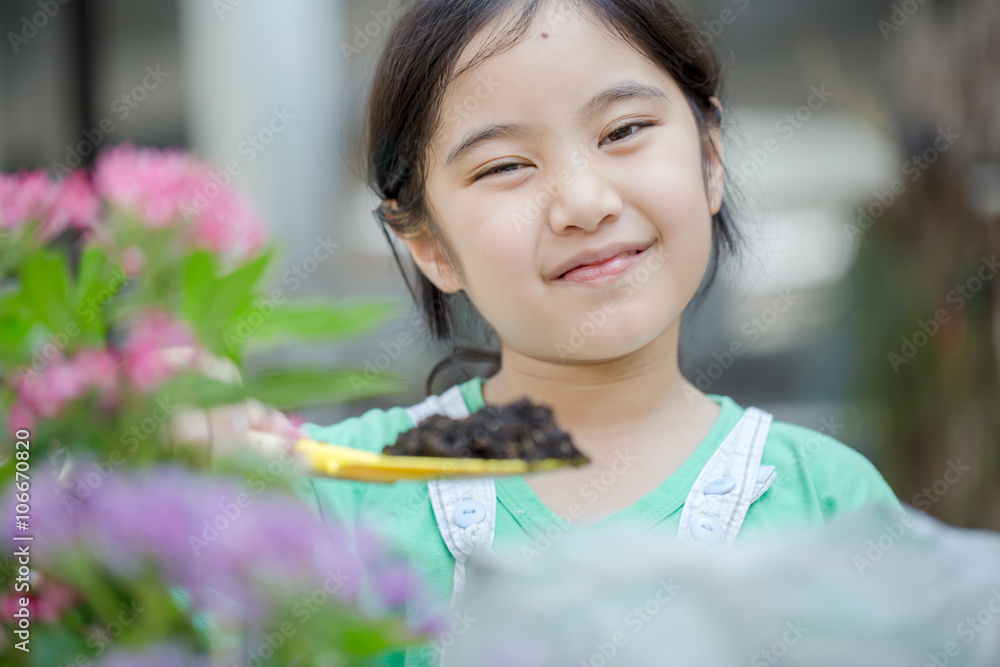 Little Asian child planting flower