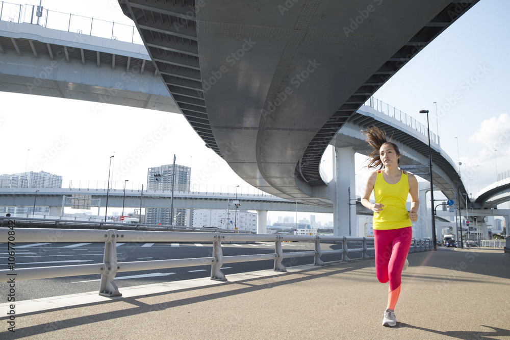 Woman runner is running under overpass