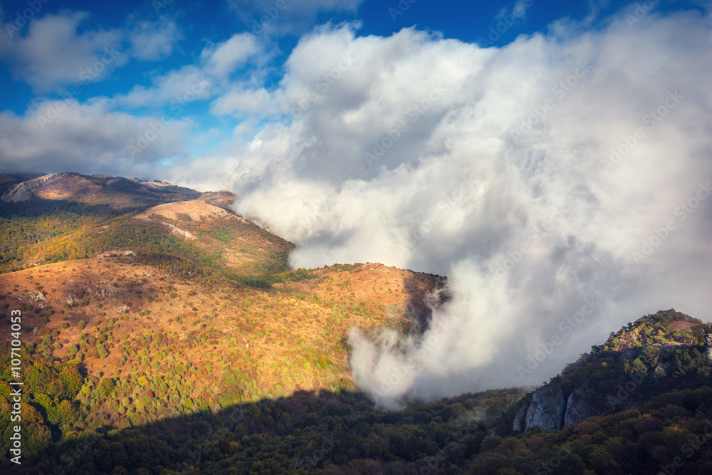 日落时壮观的秋季山景。低云