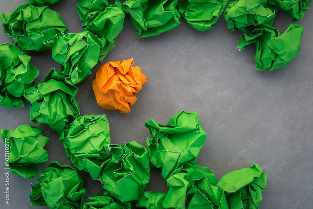 green and orange crumped paper balls on leather background.jpg