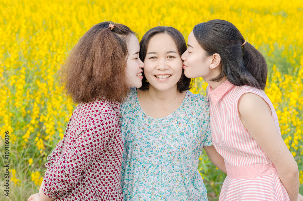 年轻的亚洲女孩在户外亲吻她们的母亲