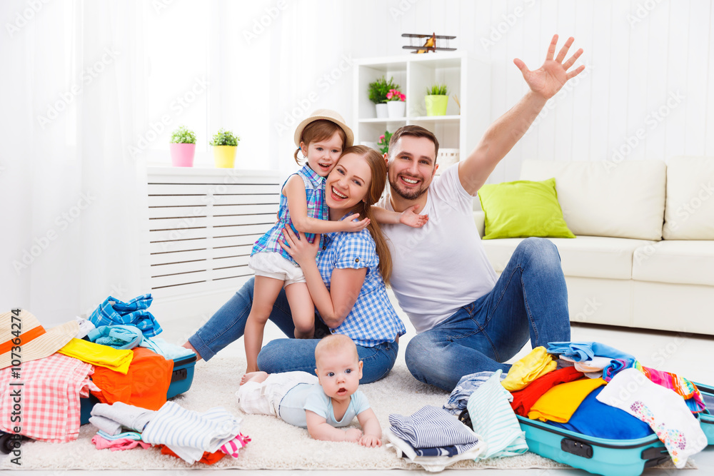 happy family mother, father and two children packed suitcases fo