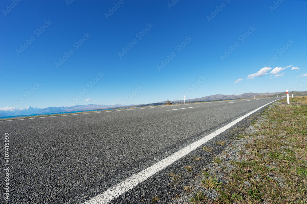 新西兰夏日湖边的柏油路