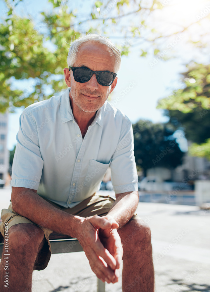 Handsome mature man sitting outdoors in the city