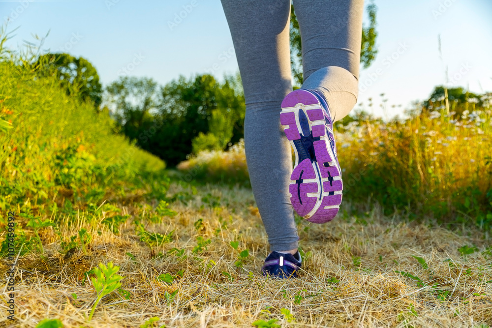 Woman running at sunset in a field