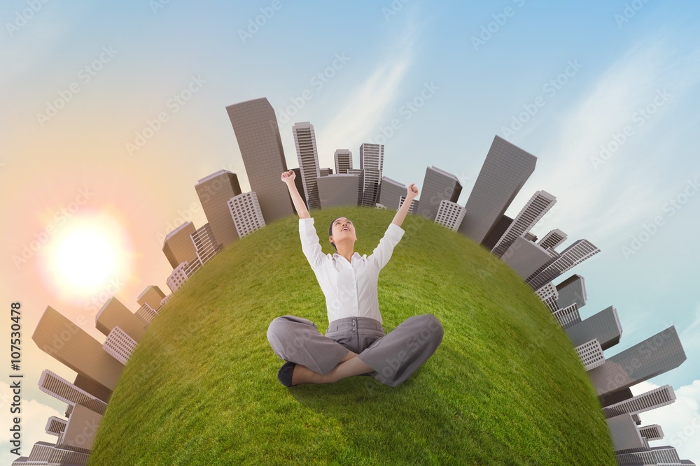 Cheering businesswoman sitting cross legged