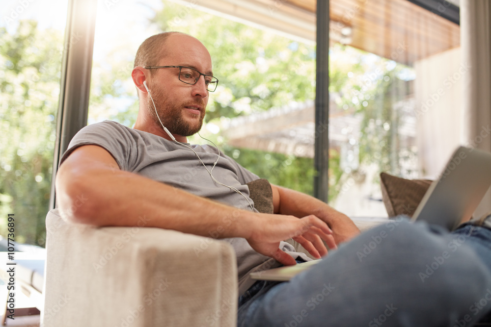 Relaxed mature man using laptop at home