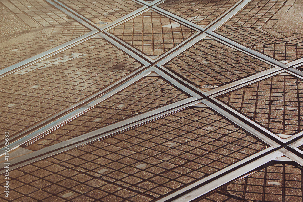 Tram lines intersection on the paved street in Zagreb, Croatia, detail, no people, warm filter appli