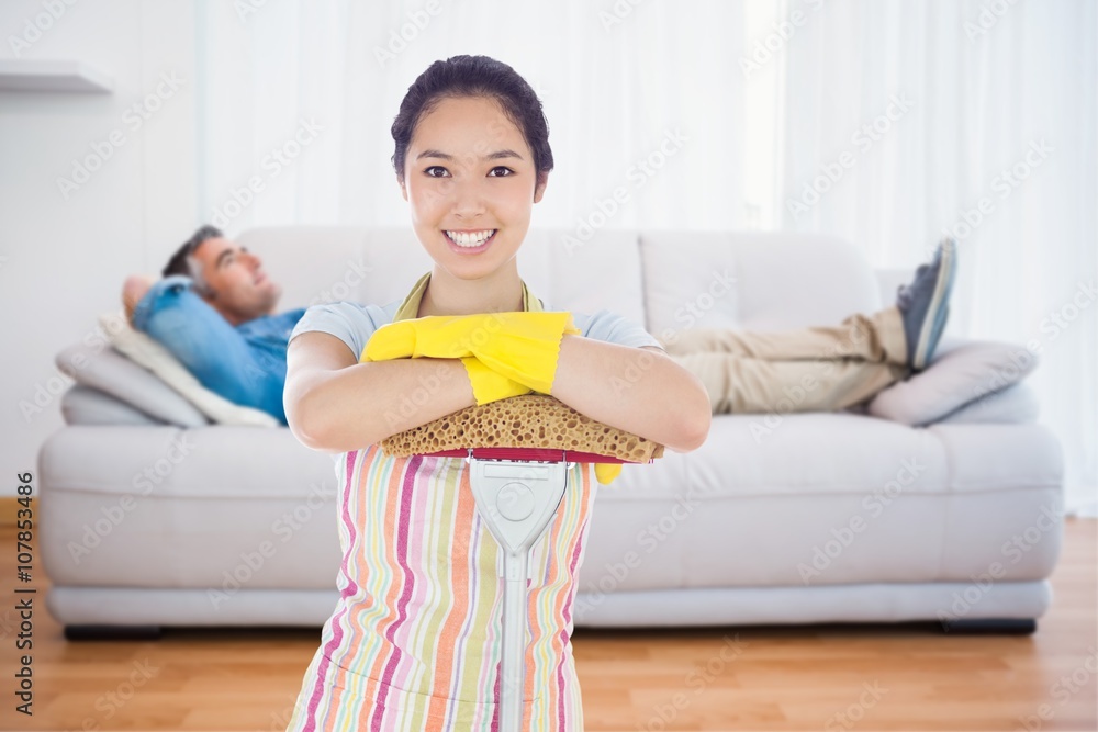 Composite image of smiling woman leaning on mop