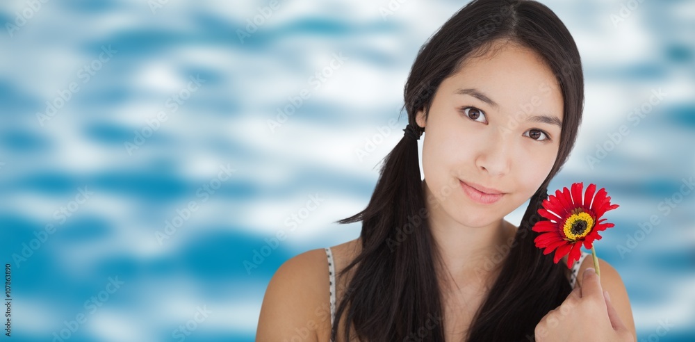 Composite image of smiling woman holding flower