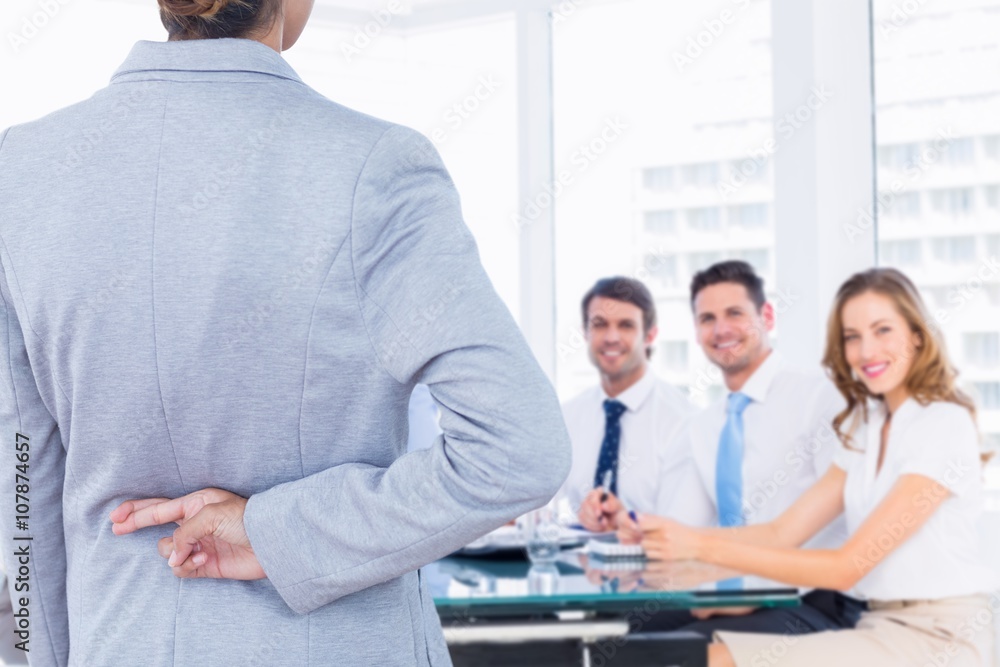 Composite image of businesswoman with fingers crossed