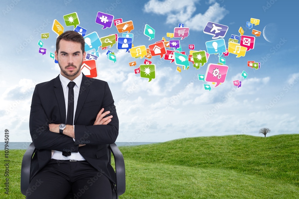 Composite image of serious businessman sitting with arms crossed