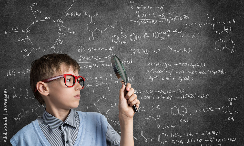 Curious school boy with magnifier