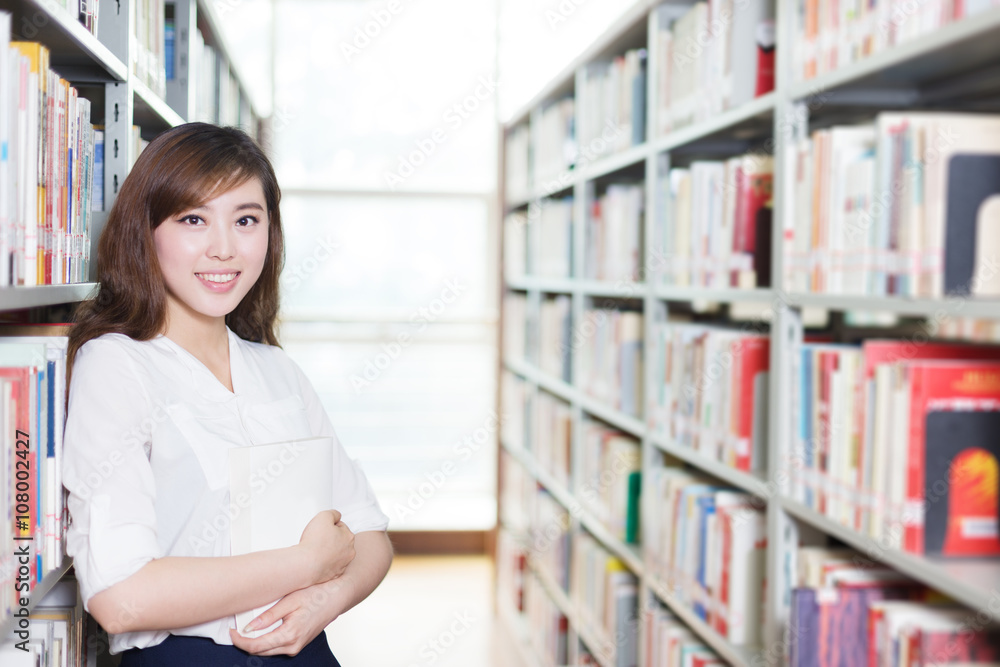 asian girl student with book in modern library