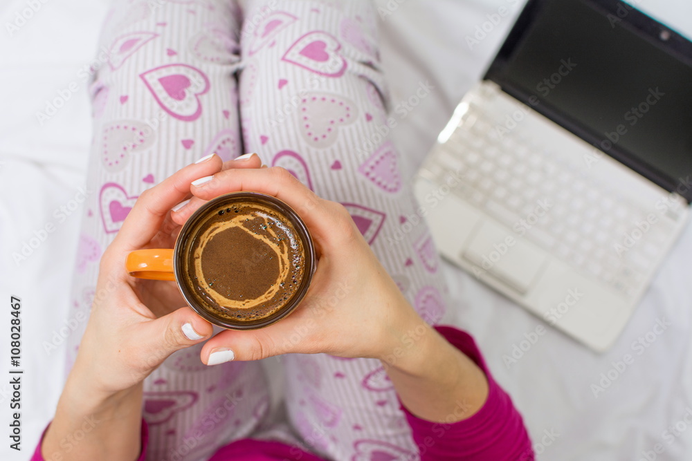 Woman having a cup of coffee in bed