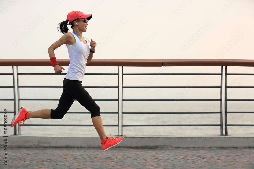 年轻健身女跑步运动员海边路跑步