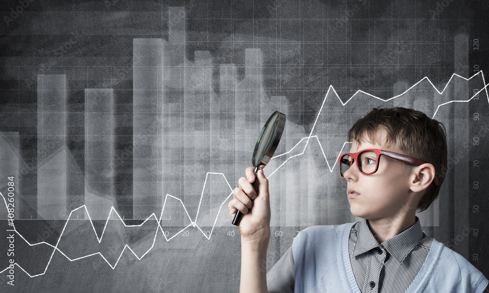 Curious school boy with magnifier