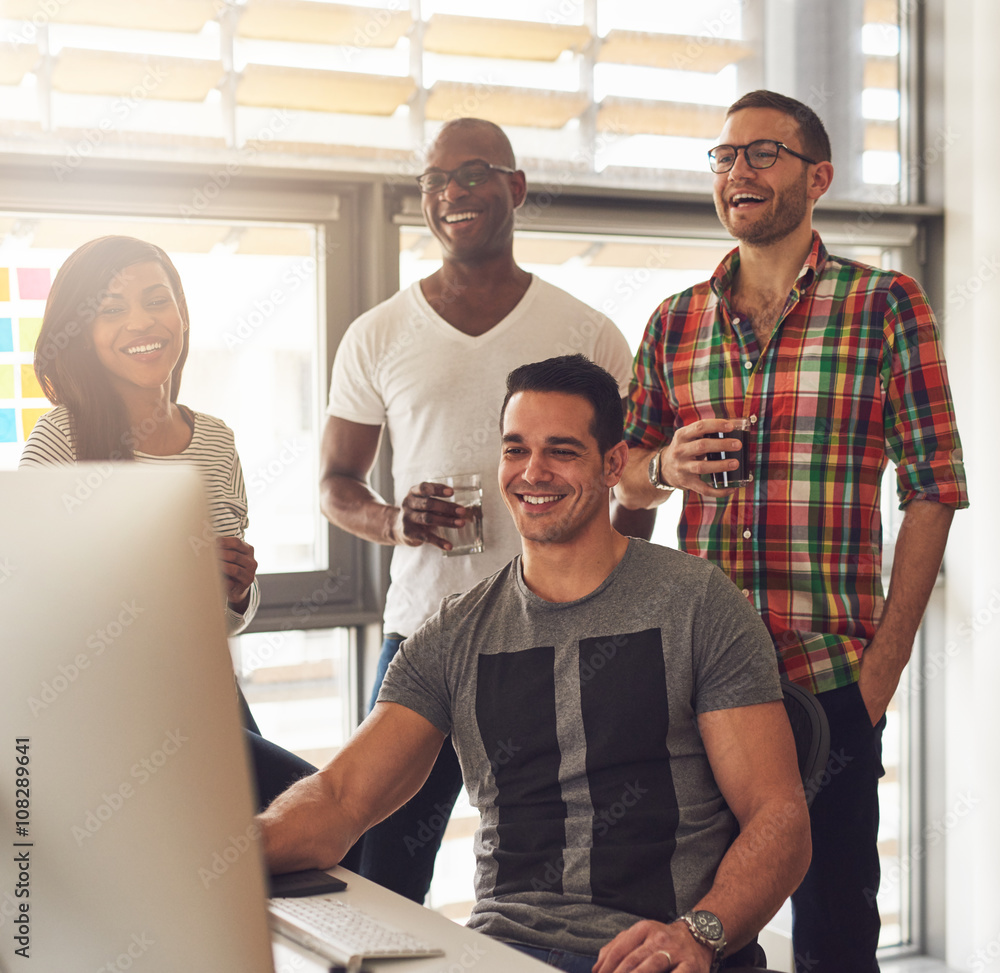 Happy quartet of young adults at desk