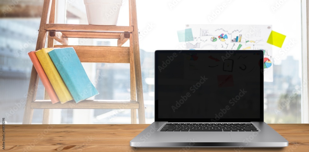 Composite image of desk with laptop