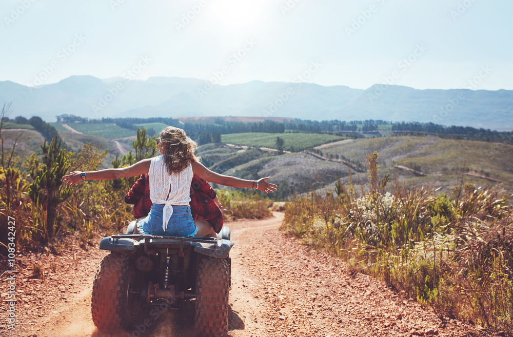 Couple having fun on a quad bike in countryside