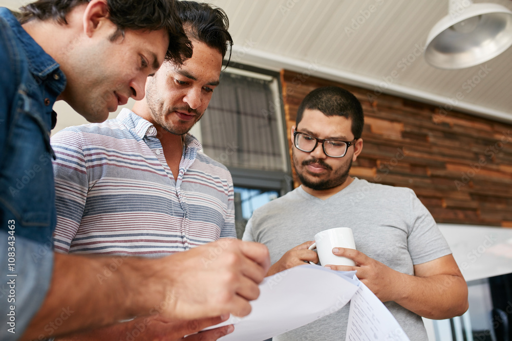 Creative people going through documents in an informal meeting